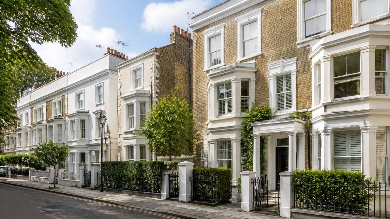 A street of period London terraces with stucco fronts and railings
