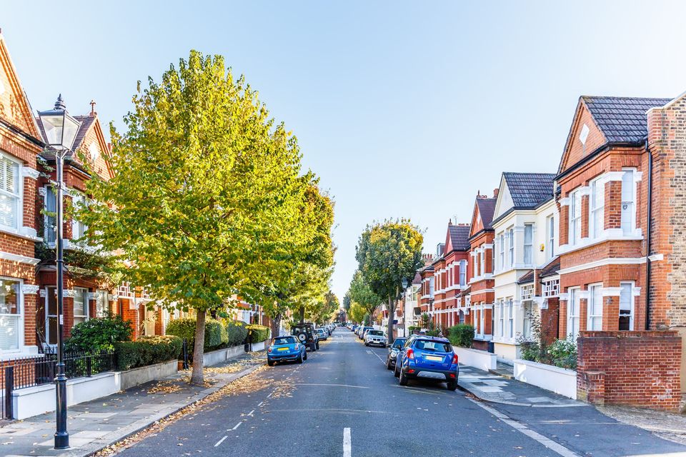 A tree-lined street of Victorian terraced houses in London